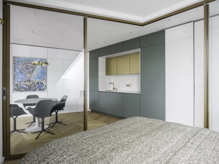 Der helle Schlafraum wirkt großzügig und schafft einen freien Blick auf den Eyecatcher der Wohnung: die farbige Küchenzeile.  Bildnachweis: Henrik Schipper für Solarlux GmbH