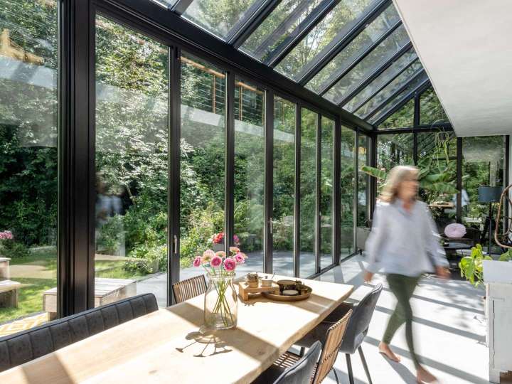 langer Wintergarten mit Esstisch und Blick ins Grüne